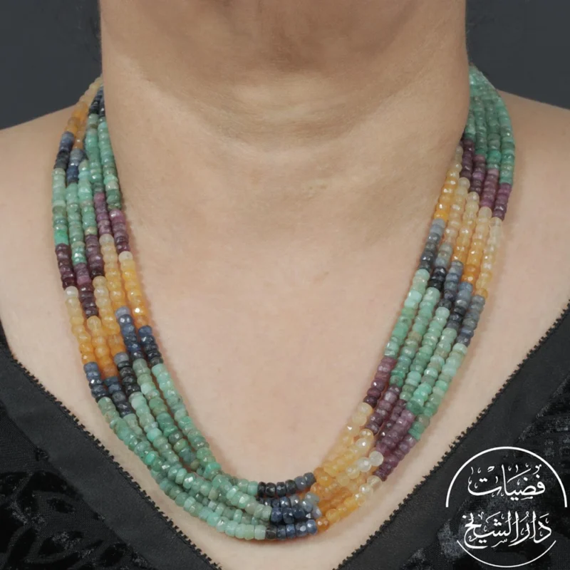 عقد متعدد الطبقات من خرز بألوان حجرية متنوعة بين الأخضر والعسلي والبنفسجي والأزرق، يظهر مرتدياً حول الرقبة بتصميم تراثي يدوي.