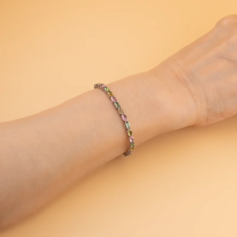 أسوارة فضة مرصّعة بأحجار تورمالين متعددة الألوان على معصم اليد